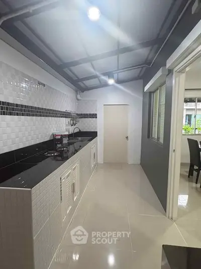 Modern kitchen with sleek black countertops and open layout design.