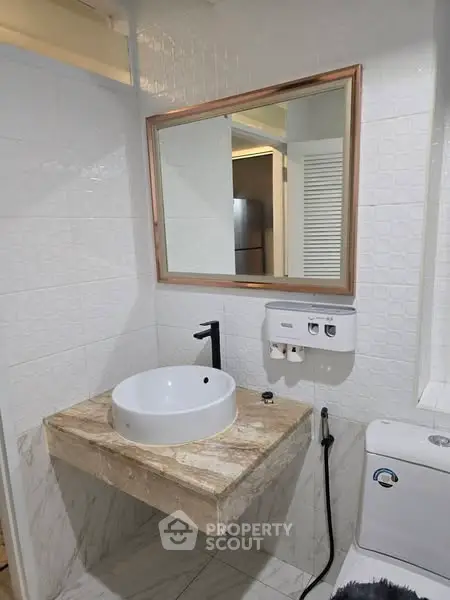 Modern bathroom with stylish sink and mirror, featuring elegant marble countertop and sleek fixtures.