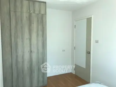 Modern bedroom with sleek wooden wardrobe and minimalist design