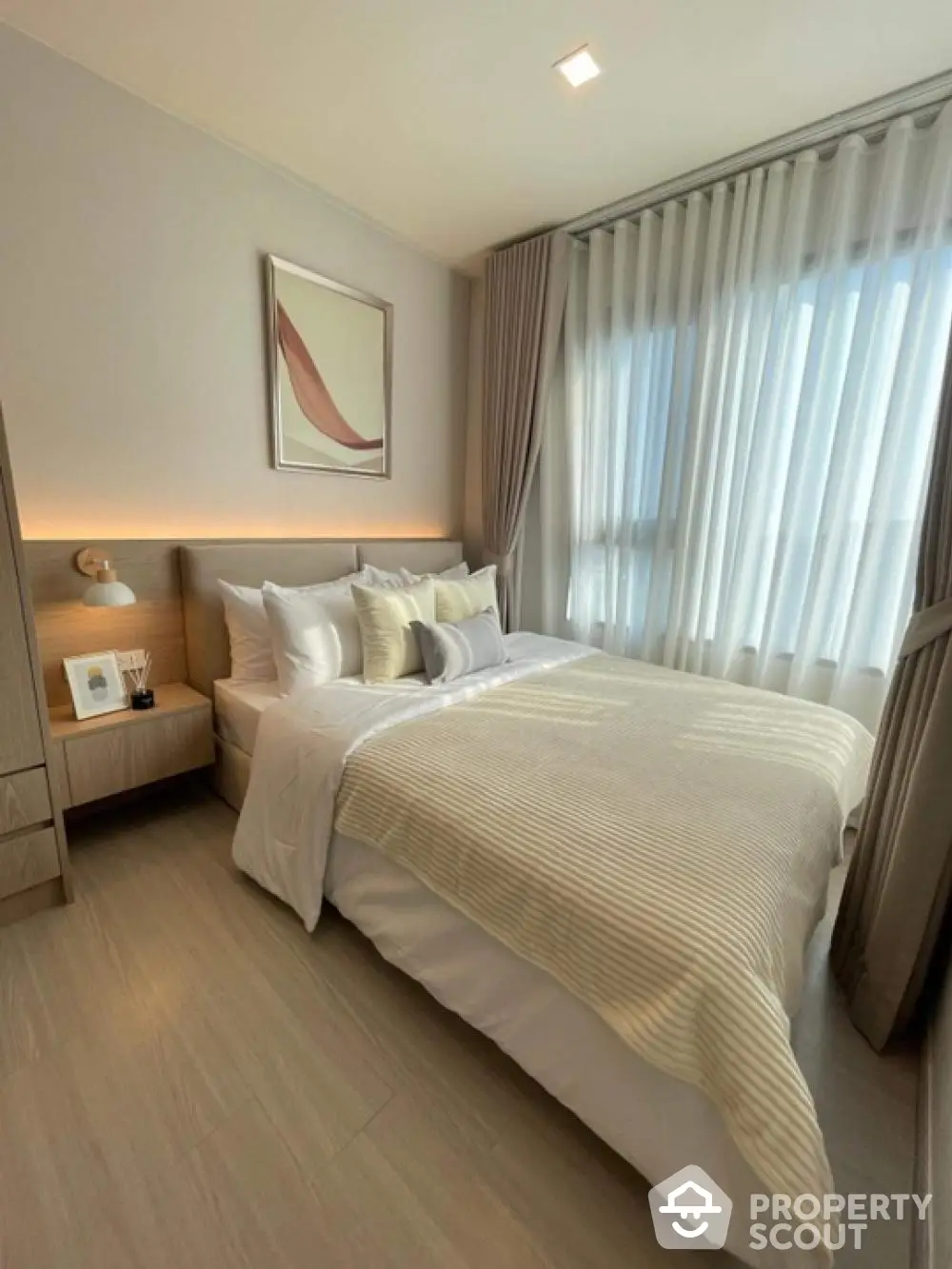 Elegant bedroom with modern decor and natural light, featuring cozy bedding and stylish curtains.