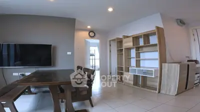 Spacious living room with modern furniture and wall-mounted TV, ideal for family gatherings.