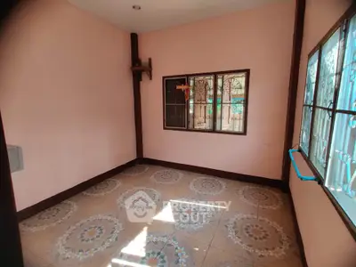 Spacious room with decorative tiled flooring and large windows for natural light.