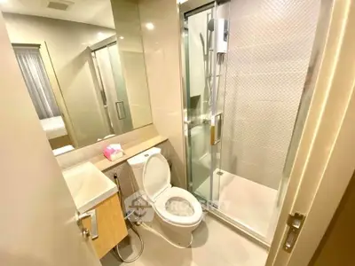 Modern bathroom with glass shower and sleek fixtures in a contemporary apartment.