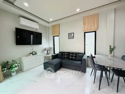 Modern living room with sleek furniture and marble flooring, featuring a wall-mounted TV and elegant dining area.