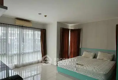 Spacious bedroom with large windows and natural light in modern apartment.