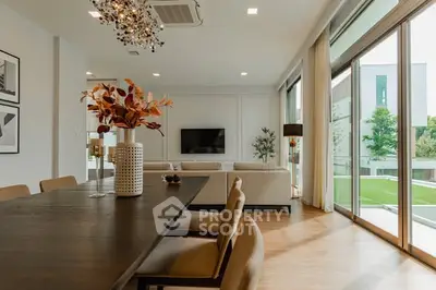 Luxurious open-plan living room with modern decor and large windows overlooking greenery.