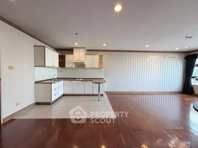 Spacious open-plan living room with modern kitchen and hardwood floors