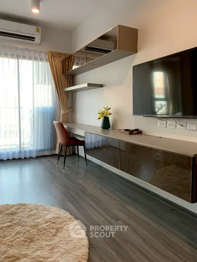 Modern living room with sleek furniture and large window, featuring a stylish workspace and elegant decor.