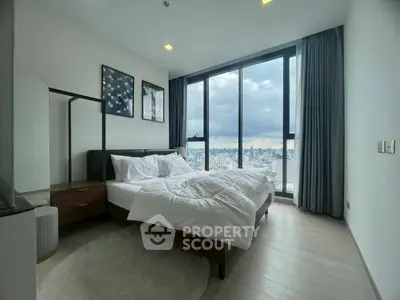 Modern bedroom with large windows offering stunning city view