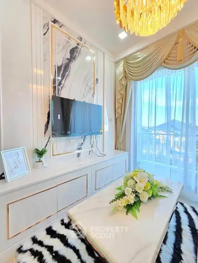 Luxurious living room with elegant decor, marble accents, and a stunning chandelier.