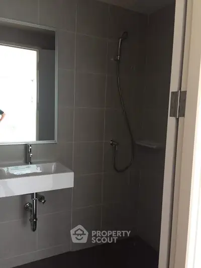 Modern bathroom with sleek shower and minimalist sink design.