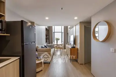 Modern living room with stylish decor and open layout, featuring a cozy sofa and dining area.