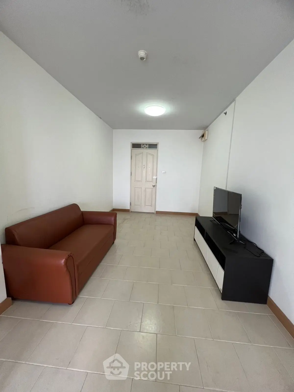 Spacious living room with modern sofa and sleek TV unit, perfect for relaxation.