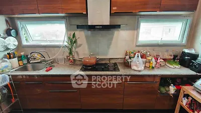Modern kitchen with sleek cabinets and dual windows for natural light