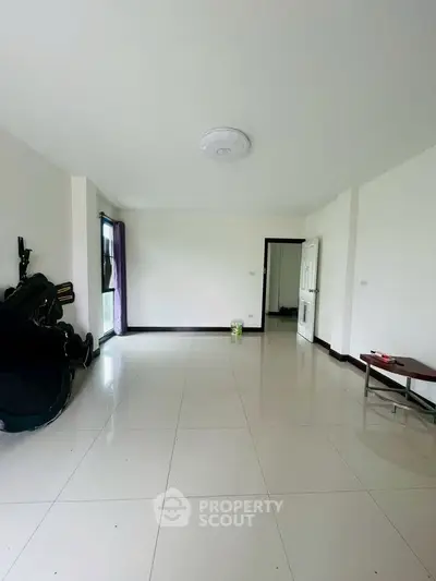Spacious empty living room with tiled flooring and minimal decor
