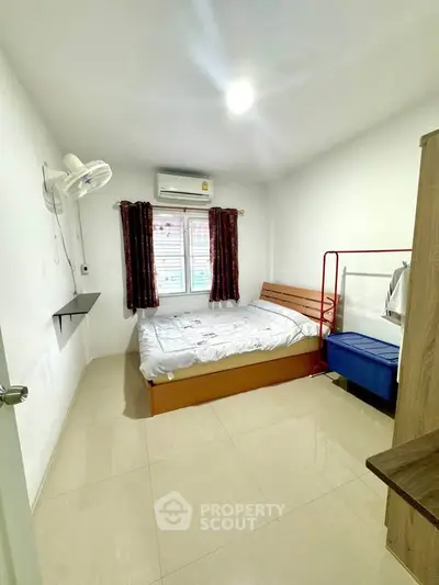 Cozy bedroom with modern furnishings and natural light, perfect for comfortable living.