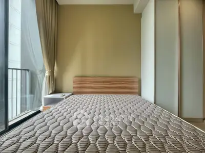 Modern bedroom with large window and minimalist design, featuring a comfortable bed and neutral tones.