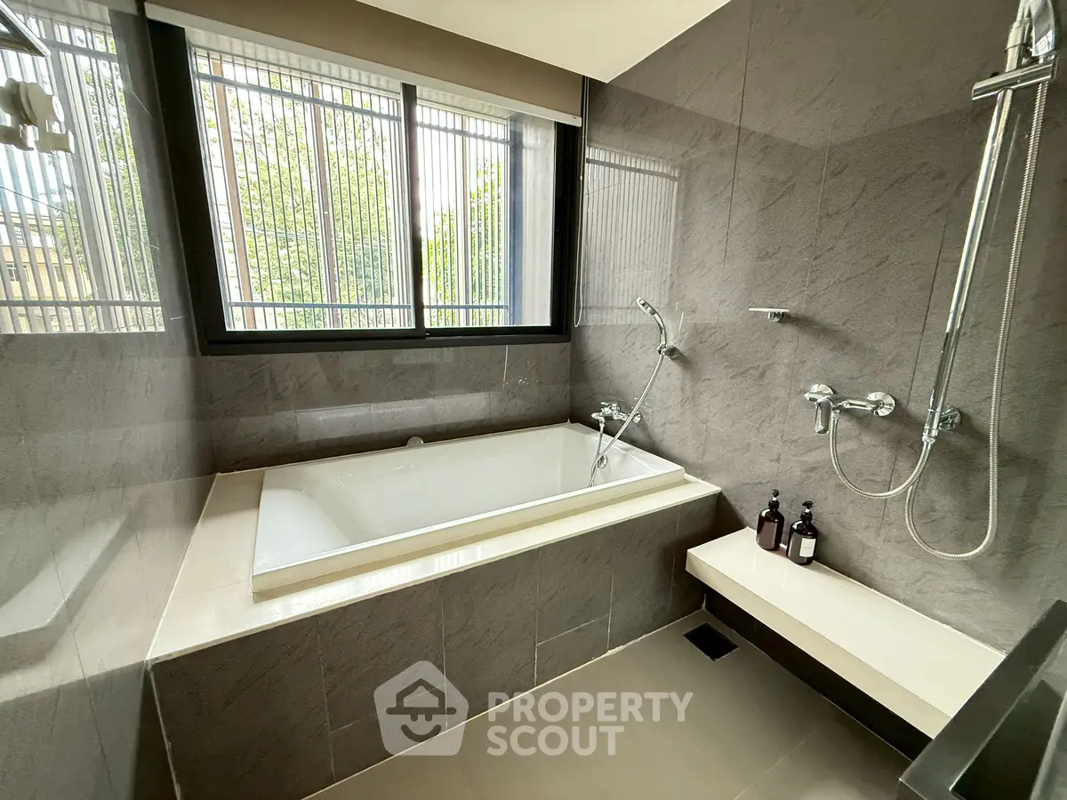Luxurious bathroom with modern bathtub and sleek fixtures, offering a serene and elegant retreat.