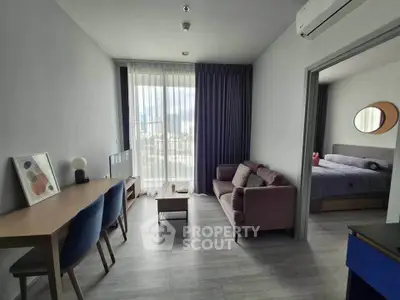 Modern living room with stylish furniture and large window offering city view