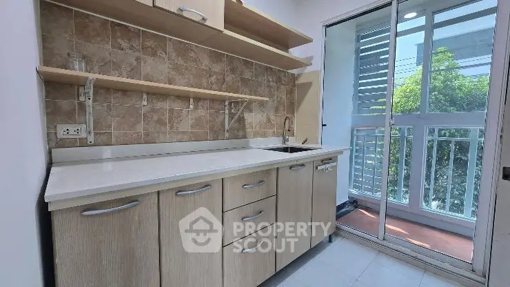 Modern kitchen with sleek cabinetry and large windows for natural light.