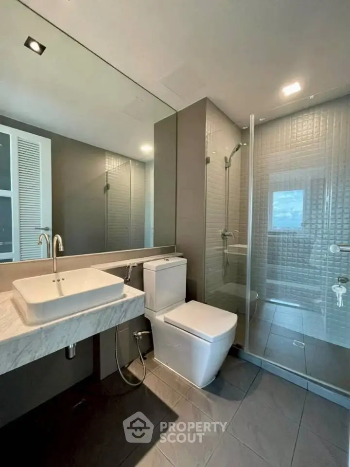 Modern bathroom with sleek fixtures and glass shower enclosure