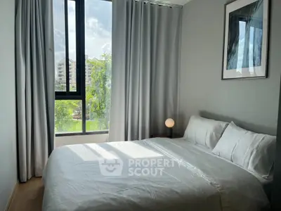 Bright and cozy bedroom with large window and modern decor in a stylish apartment.