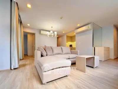 Spacious modern living room with elegant beige sofa and open kitchen layout