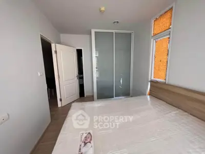 Modern bedroom with large bed and sliding closet doors in a bright apartment.