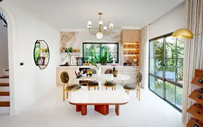 Luxurious open-plan kitchen with elegant dining area and large windows overlooking garden