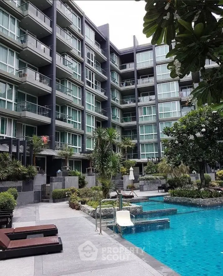 Modern condominium with poolside view and lush greenery, perfect for urban living.