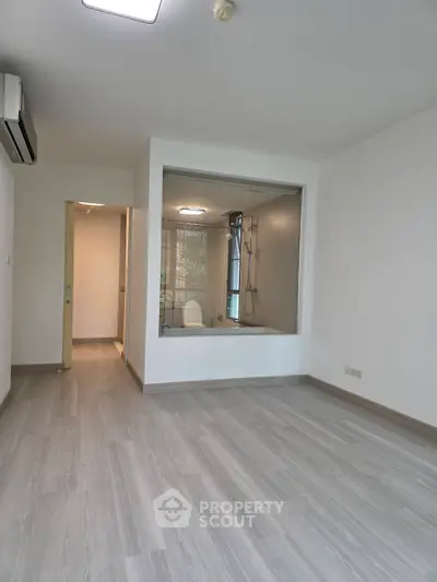 Spacious modern living room with large window and sleek flooring