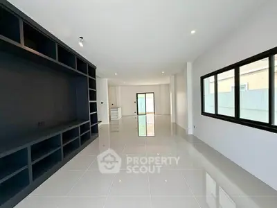 Spacious modern living room with sleek tile flooring and large windows for natural light.