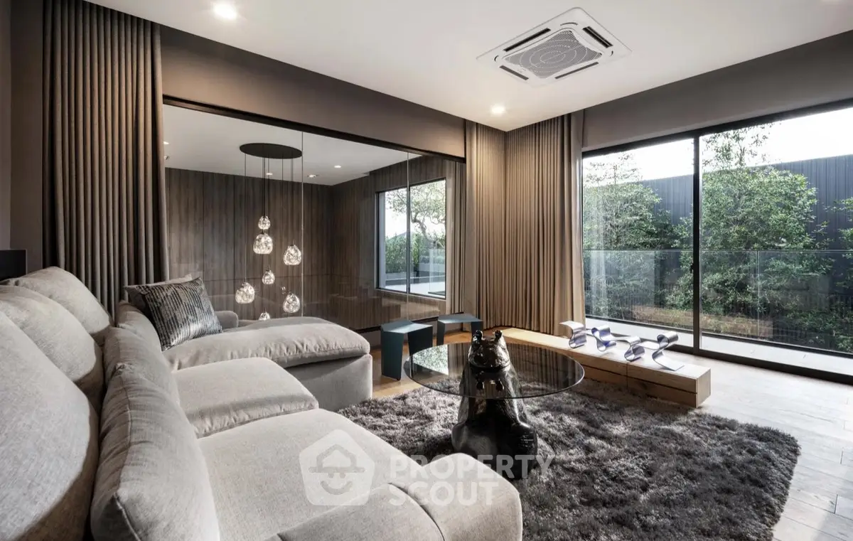 Luxurious modern living room with plush sofa and large windows overlooking garden.