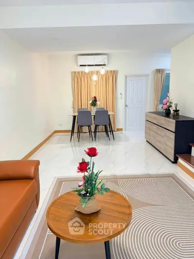 Modern living room with stylish furniture and elegant decor, featuring a cozy dining area and air conditioning.