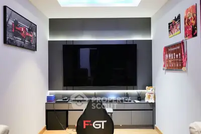Modern entertainment room with sleek TV setup and gaming chair, perfect for relaxation and gaming enthusiasts.