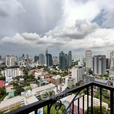 Stunning cityscape view from a high-rise balcony with dramatic clouds overhead.