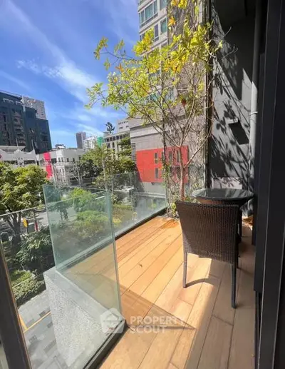 Charming urban balcony with glass railing and city view, perfect for relaxation and enjoying the outdoors.