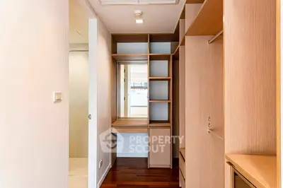 Spacious walk-in closet with wooden shelving and natural light