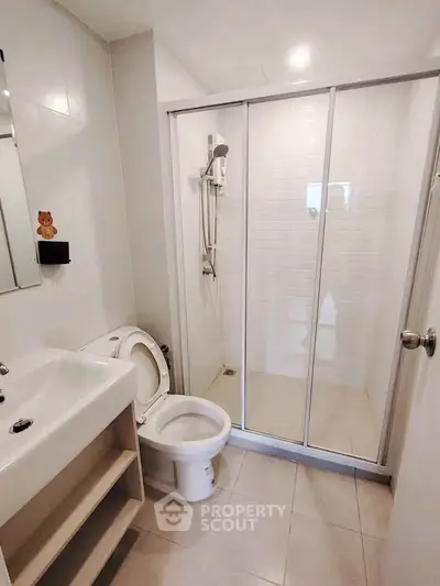 Modern bathroom with glass shower enclosure and sleek fixtures
