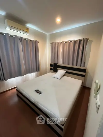 Cozy bedroom with modern bed and air conditioning, perfect for restful nights.
