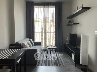 Modern living room with sleek furniture and large window view.