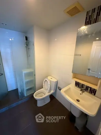 Modern bathroom with shower, toilet, and sink in a sleek design.