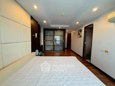 Spacious modern bedroom with elegant decor and wooden flooring