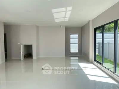 Spacious modern living room with large windows and sleek tile flooring