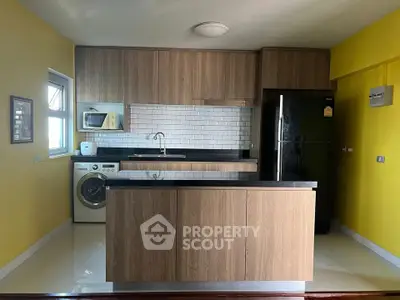 Modern kitchen with wooden cabinets, island, and appliances in a bright yellow room.
