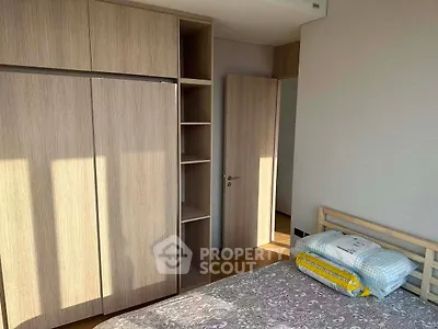 Spacious bedroom with wooden wardrobe and natural light, perfect for cozy living.