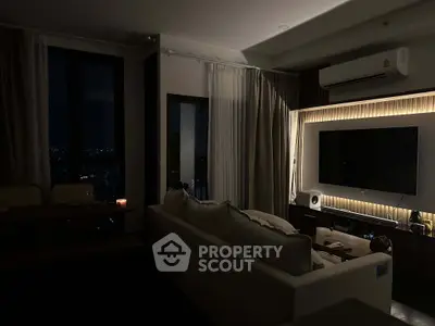 Cozy modern living room with ambient lighting and city view, featuring a large TV and stylish decor.
