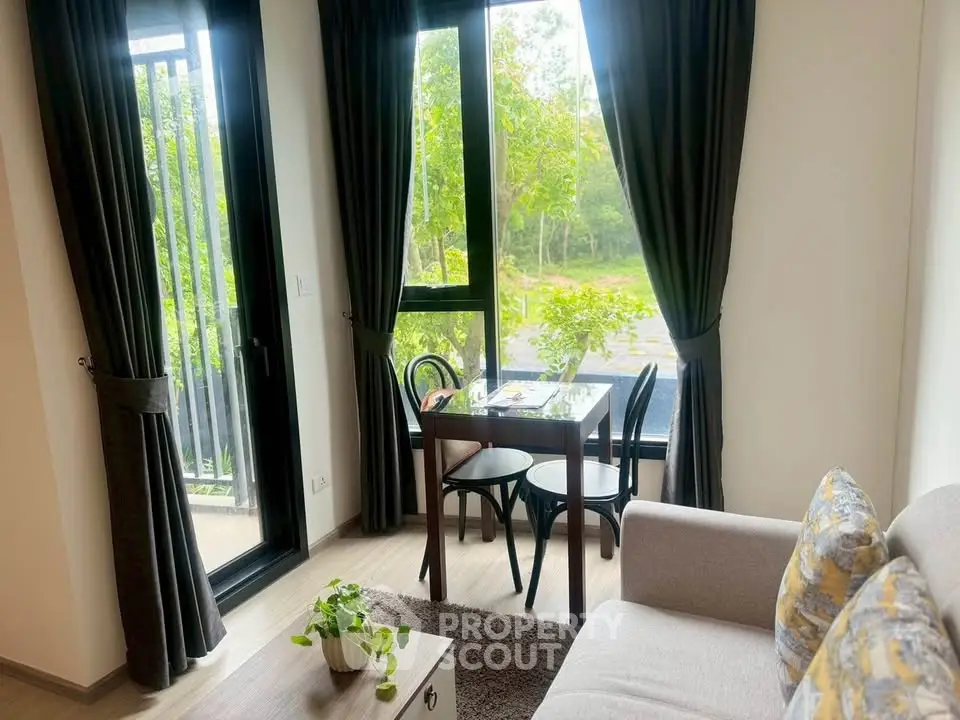 Cozy living room with large windows and lush garden view, featuring modern furniture and elegant decor.