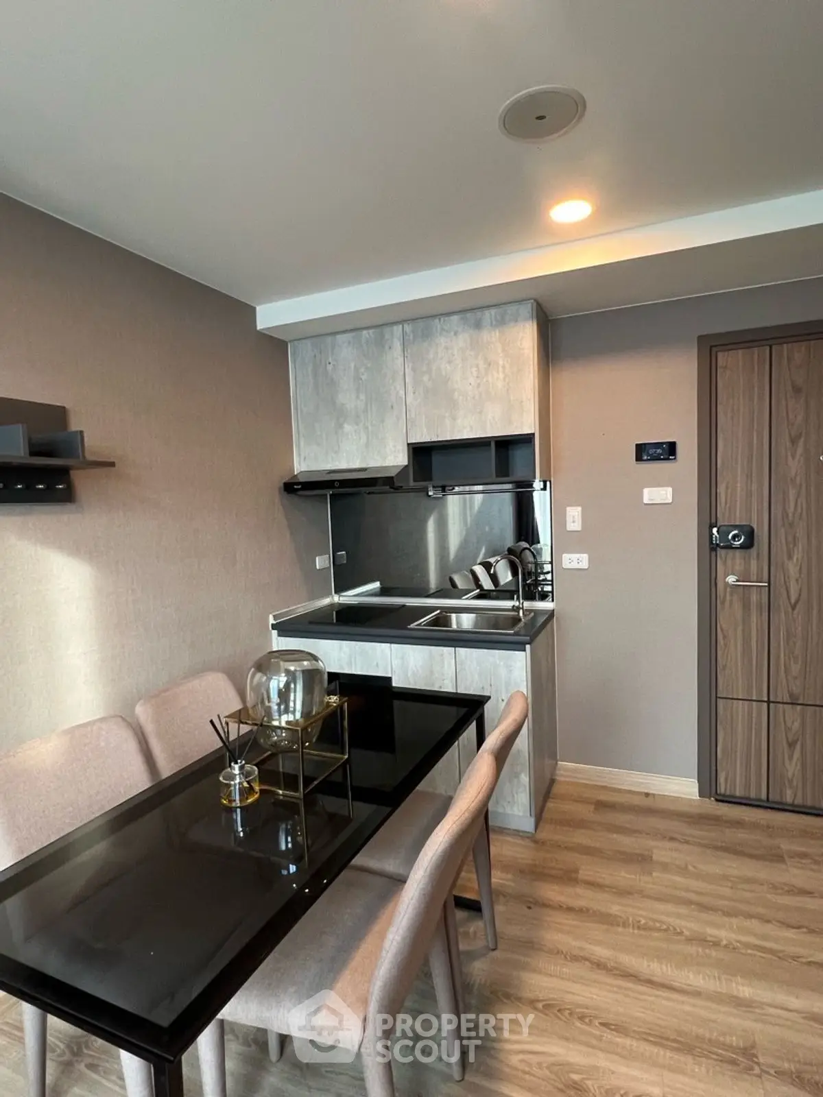 Modern kitchen with sleek dining area and wooden flooring in a stylish apartment.