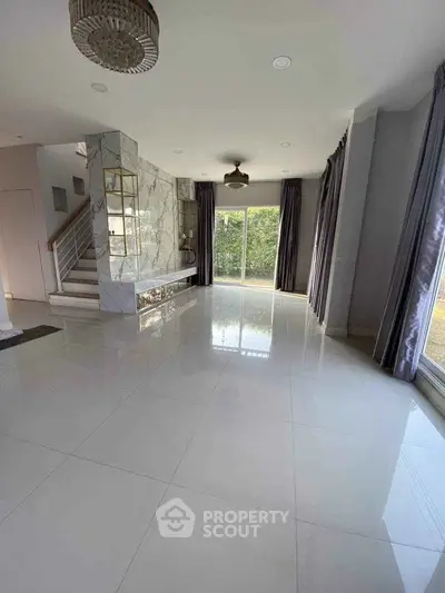 Spacious modern living room with large windows and elegant marble accents
